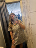 Person wearing a leopard print dress taking a mirror selfie.